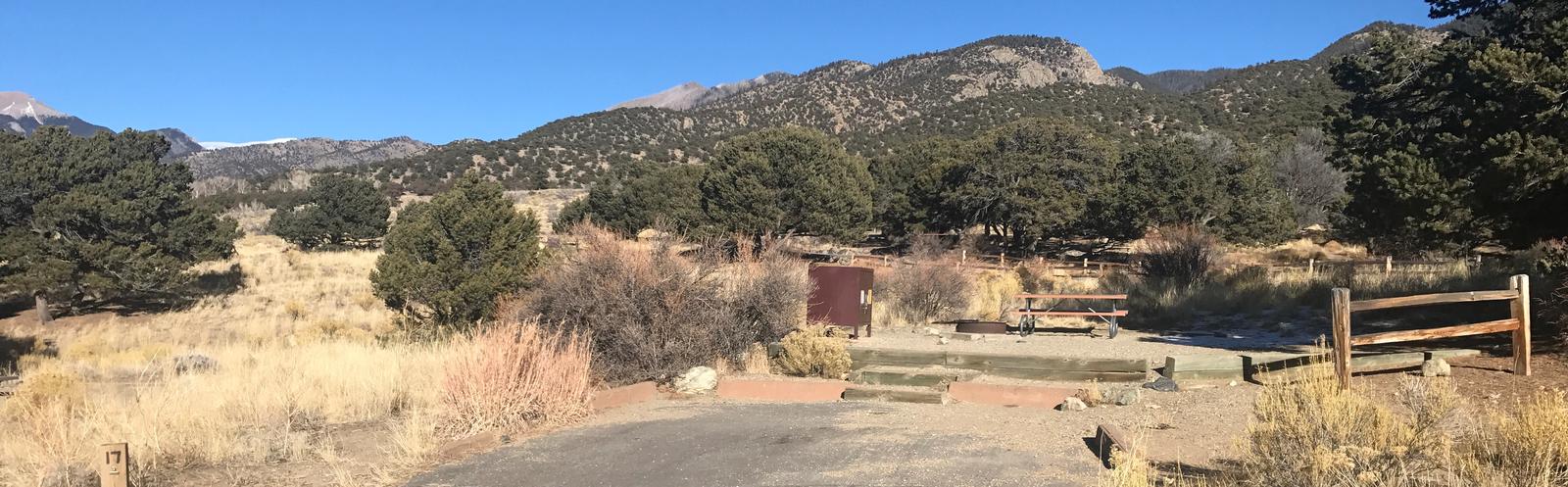 Wide view of Site #17 parking pad, stairs, fenced tent pad, bear box, fire ring, and picnic table. Mountains can be seen in the background.Site #17, Pinon Flats Campground