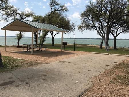 RV site with covered picnic table, grill, and fire ring with great view of Waco Lake