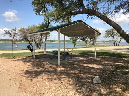 Covered picnic table, grill, fire ring, and Waco Lake in the background