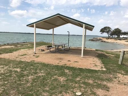 Tent site with covered picnic table and fire ring.  Site is located very close to shoreline of Waco Lake