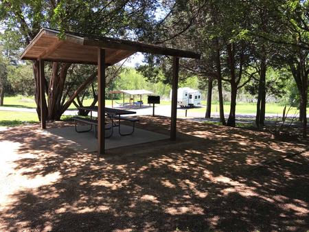 Covered picnic table, grill, and fire ring at site
