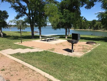 Picnic table, grill, and fire ring at site with great view of Waco Lake