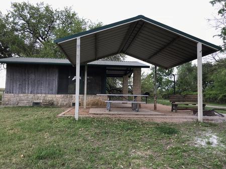 Screen shelter with covered picnic table, grill, and fire ring