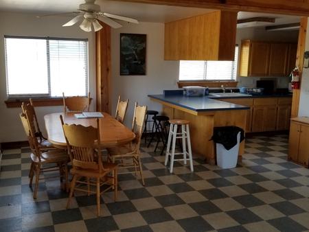 Inside of the Caretaker's cabin showing the kitchen and dining area with bar and table with 6 chairsCaretaker's Cabin kitchen and dining room