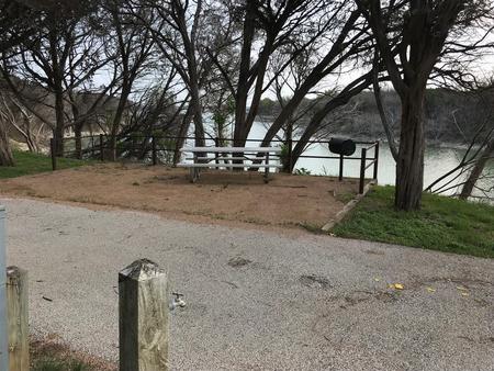 Picnic table and grill at site with Waco Lake in the background