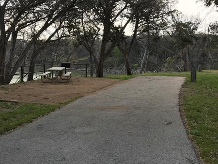 RV site with picnic table, grill, and Waco Lake in the background