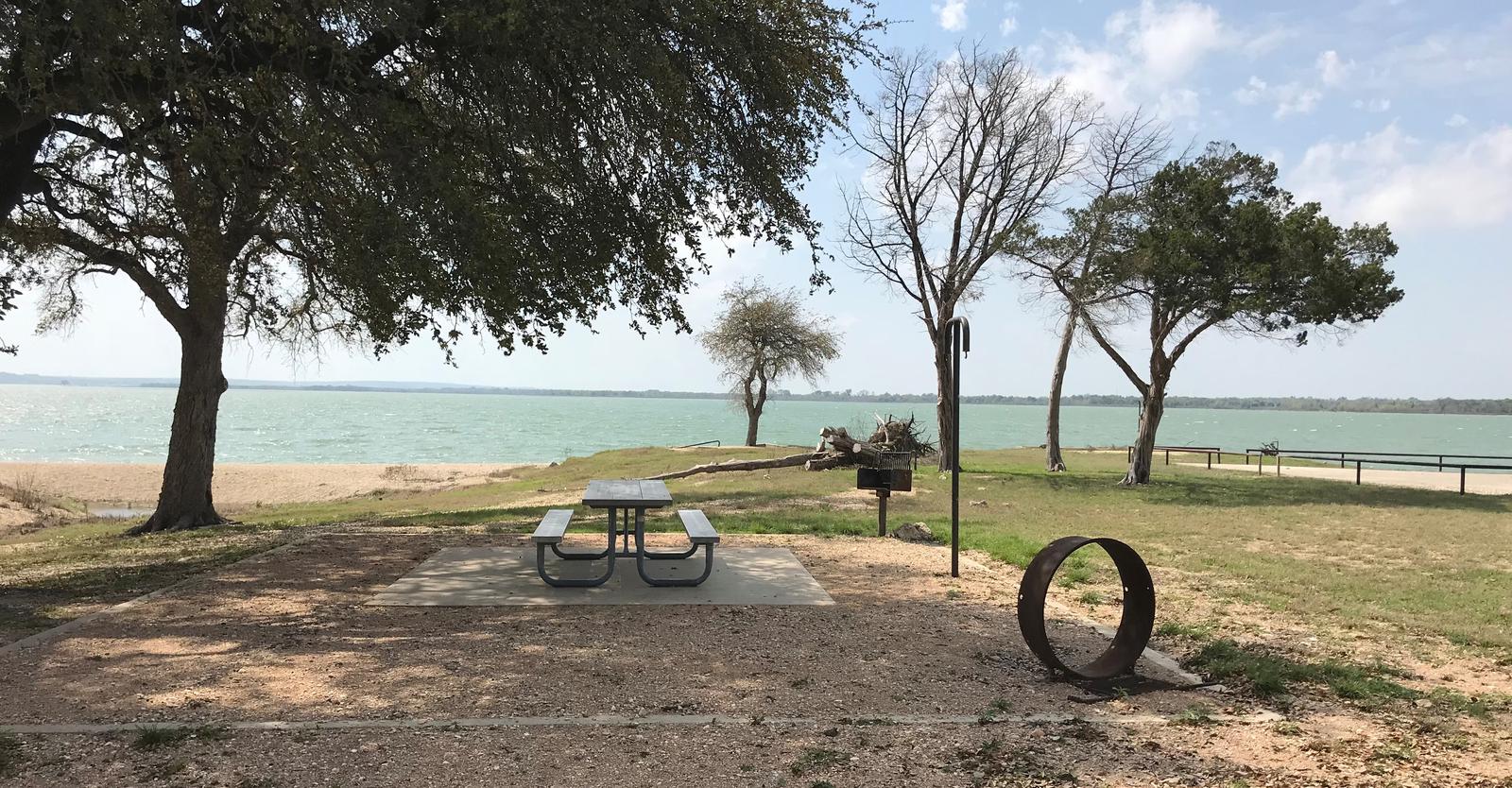 Tent site with picnic table, grill, and fire ring.  Site is located very close to shoreline of Waco Lake 