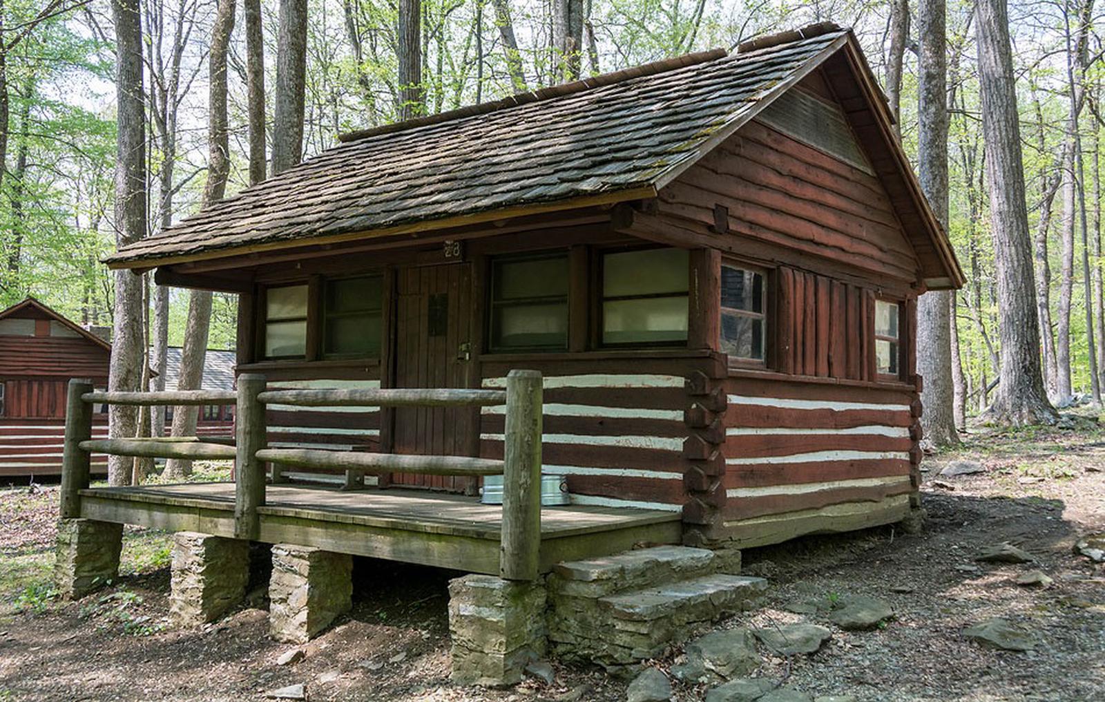 Camp Misty Mount Cabin 28Camp Misty Mount Cabin 28. An American chestnut log cabin with a porch and stone stairs on the front of the cabin.