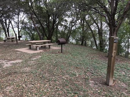 Tent site with picnic table, grill, and Waco Lake in the background