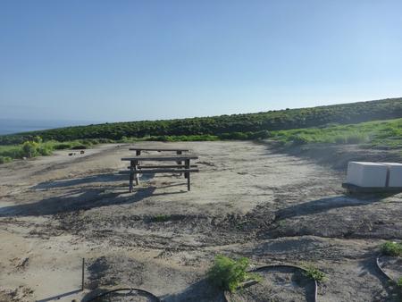 Picnic table and food storage box surrounded by low bushes and grass overlooking ocean.  SANTA BARBARA ISLAND AREA - 005A
