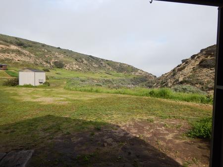 View of wide canyon with picnic table and green grass in foreground. Santa Rosa campground