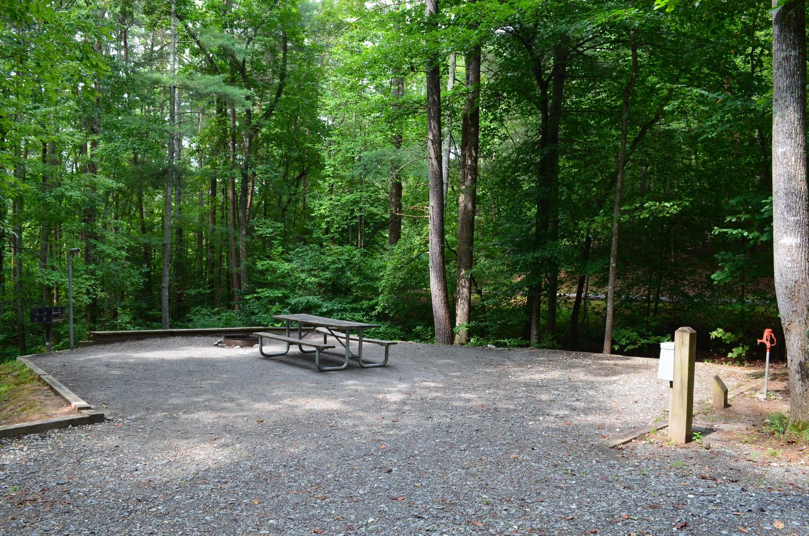 Gravel site with fire pit, table, grill