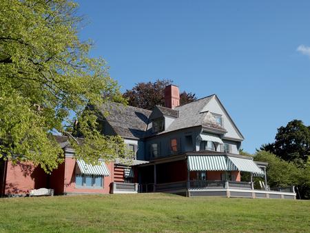 A gray and brick house atop a grassy hill.Theodore Roosevelt's home.