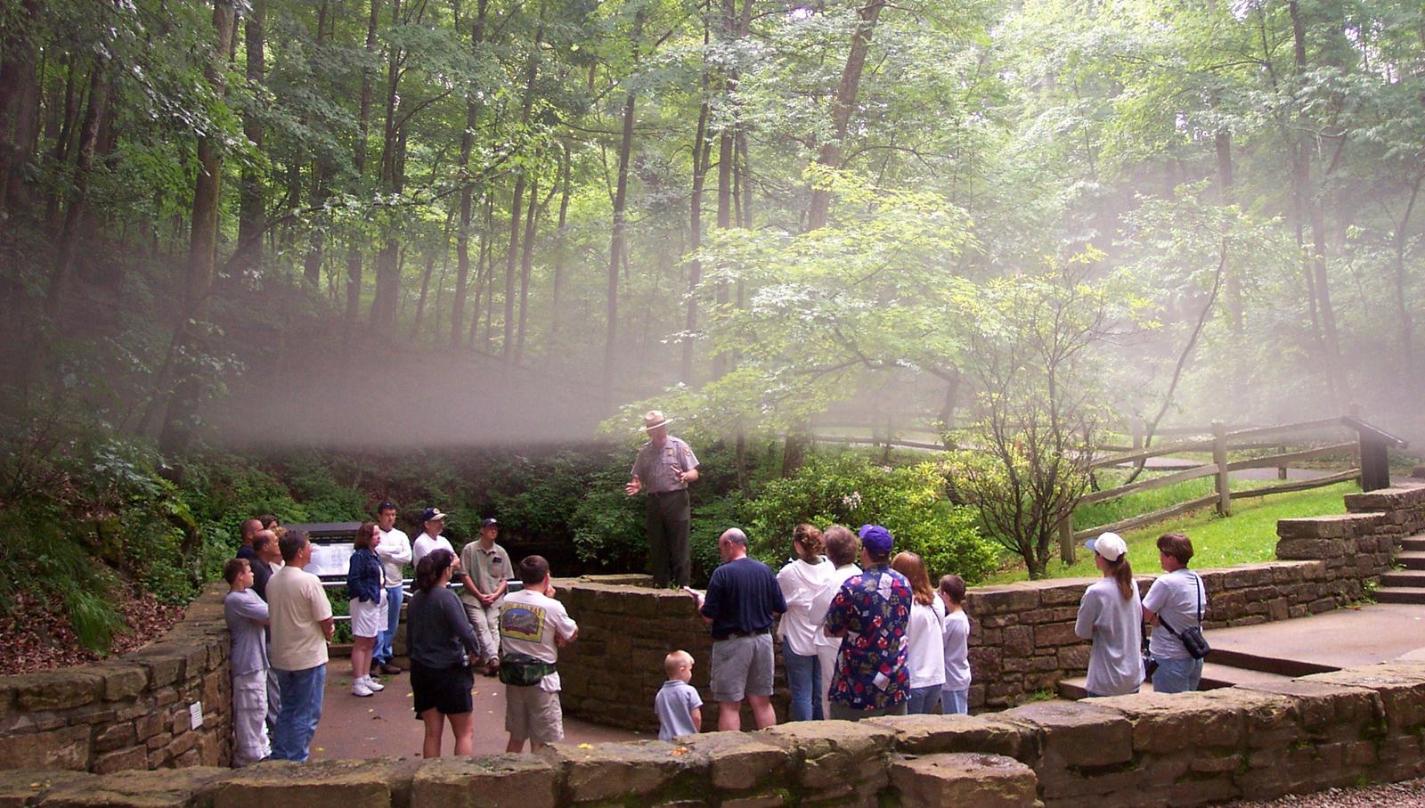 A fog layer separates over a waiting tour as cool cave air meets summer swelter at the Historic Entrance.