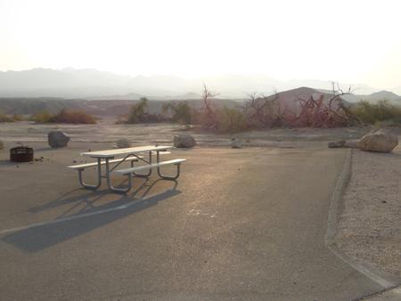 Furnace Creek Campground standard nonelectric site #54 with picnic table and shared fire ring with site #55.