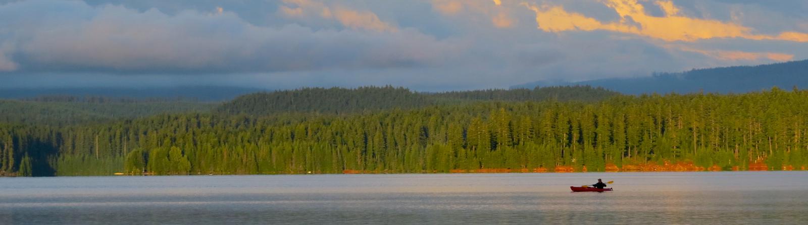 Panoramic photo of the lake and mountains beyond Timothy LakeA quiet evening paddle is a great way to wind down