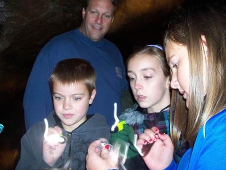 Kids and Family Discovery TourKids with flashlights exploring cave