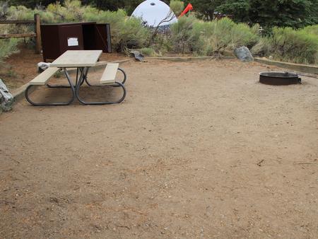 View of site #9 tent pad, fire ring, picnic table, and bear box. In the background you can see the tent from neighboring site #7.Site #9, Pinon Flats Campground