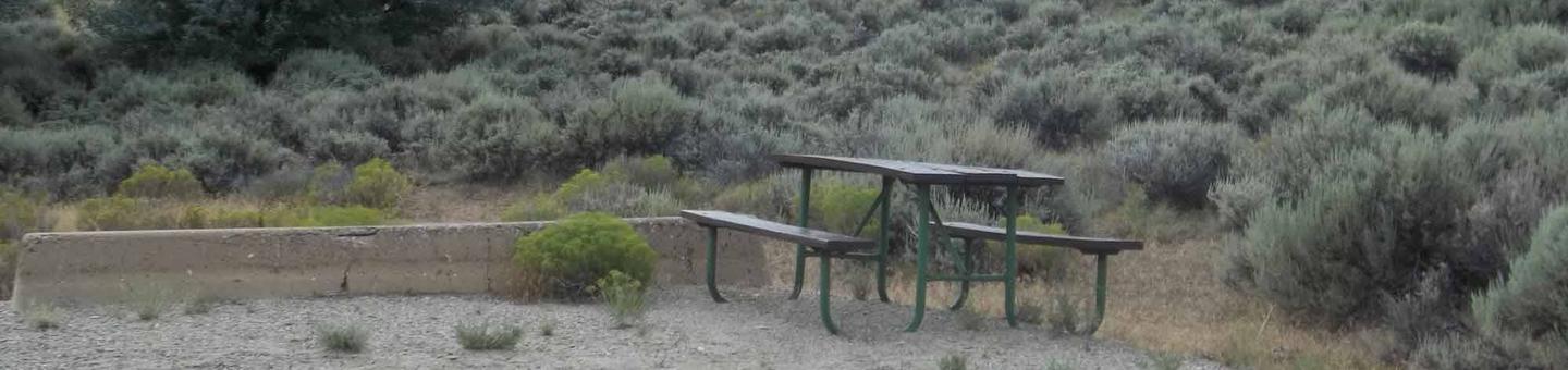 Picnic table at the end of a sandy parking area with sagebrush in the backgroundAntelope Flat Campground: Site 20