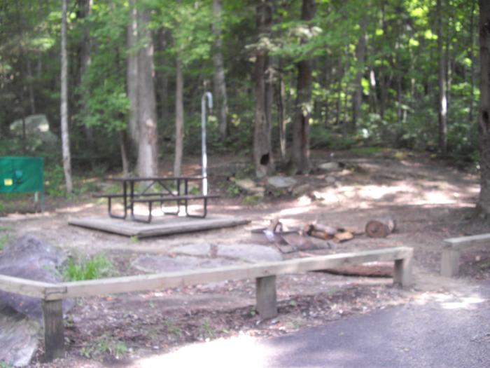 Picnic table sits next to green food storage locker and gray lantern post.Site 2 Rock Creek Campground