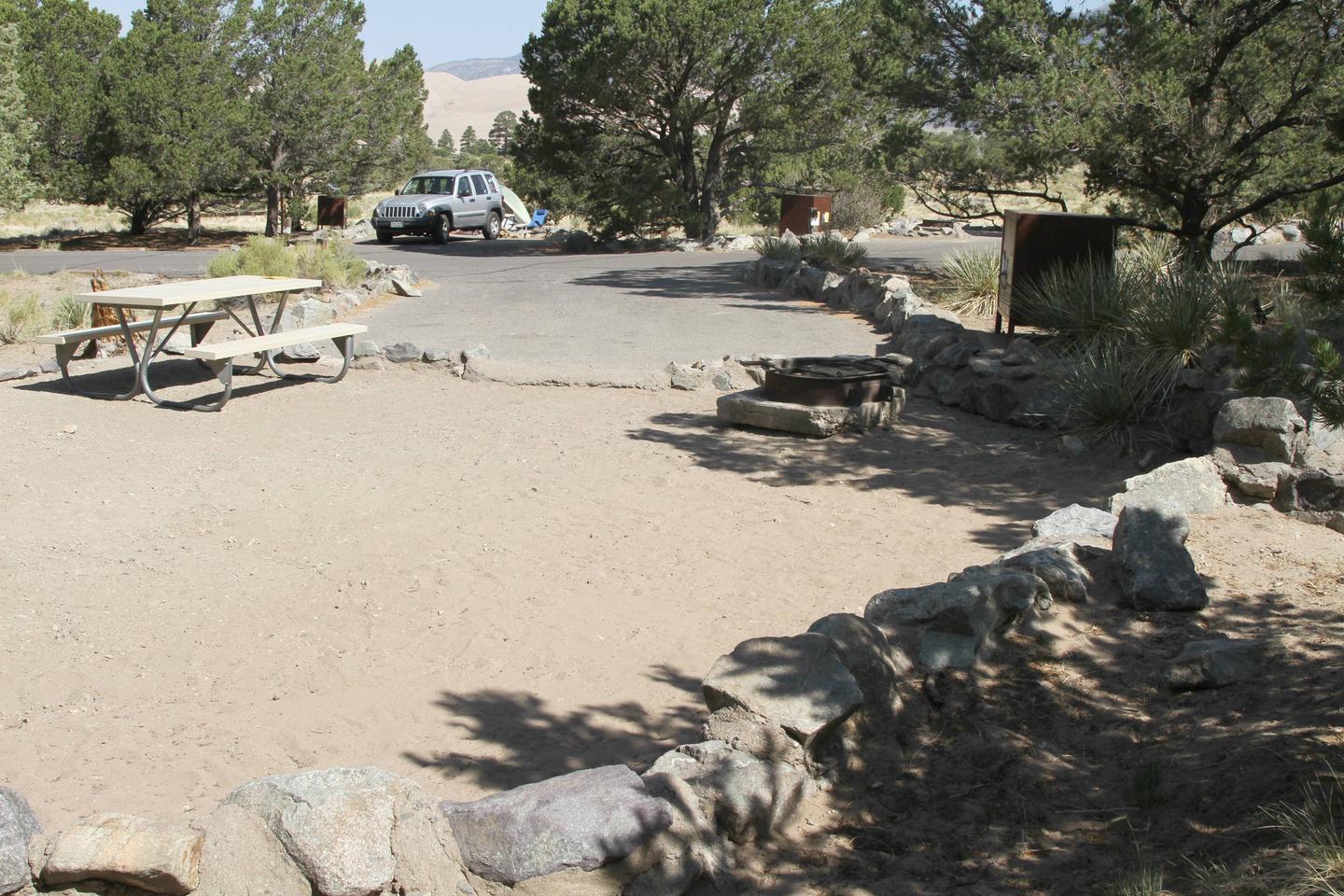 Back view of Site #65 tent pad with picnic table, fire ring, and bear box. Sites #64 and #66 can be seen in background.Site #65, Pinon Flats Campground