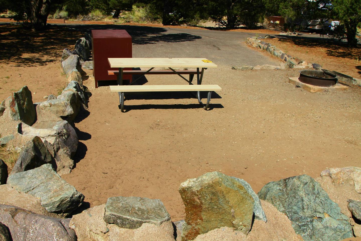 Back view of Site #75 tent pad, with picnic table, bear box, and fire ring. Parking pad in background.Site #75, Pinon Flats Campground