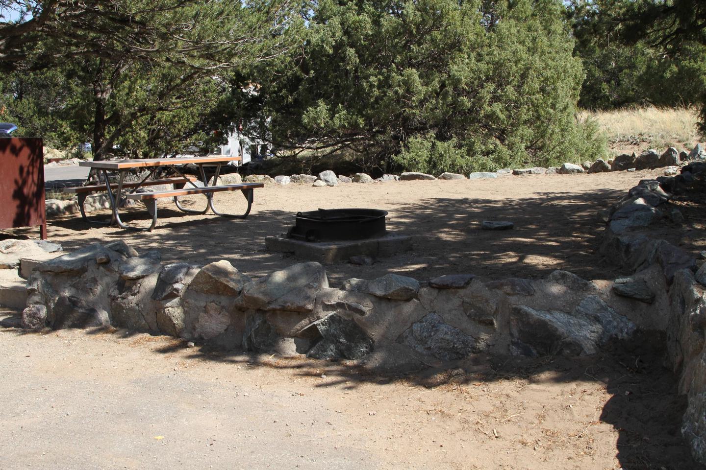 Side view of Site #79 tent pad with bear box, picnic table, and fire ring. Pine trees surround most of tent area.Site #79, Pinon Flats Campground