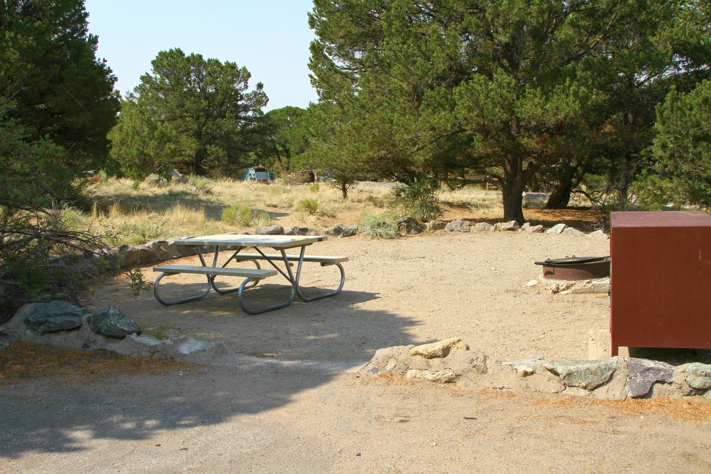 Closer up view of Site #74 tent pad, with bear box, picnic table, and fire ring. Tent pad is bordered by a low rock wall.Site #74, Pinon Flats Campground