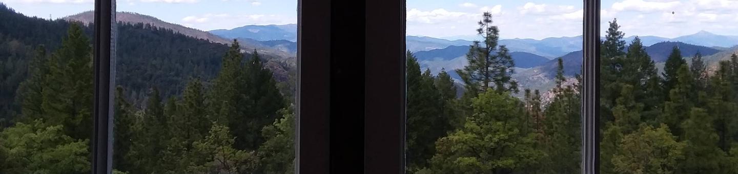 View of mountains and sky looking out window.One of the many changing views visitors will have looking out the bank of windows from the cab of the Post Creek Guard Station.