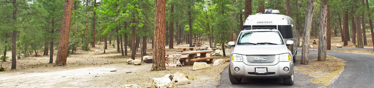 A car and trailer in the parking spot next to a picnic table and fire pit, Mather CampgroundA car and trailer in the parking spot next to a picnic table and fire pit, Aspen Loop 6 Mather Campground