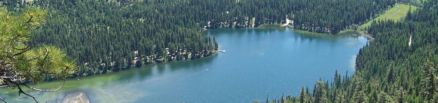 Aerial view of flat lake reflecting forested surroundings.Aerial view of Bonaparte Lake