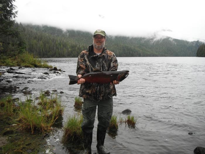 Fisherman holding coho salmon in front of Anan LakeCoho salmon caught in Anan Lake in September