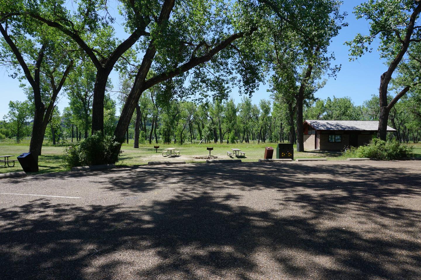 Parking area with the restroom and picnic tables in the distance