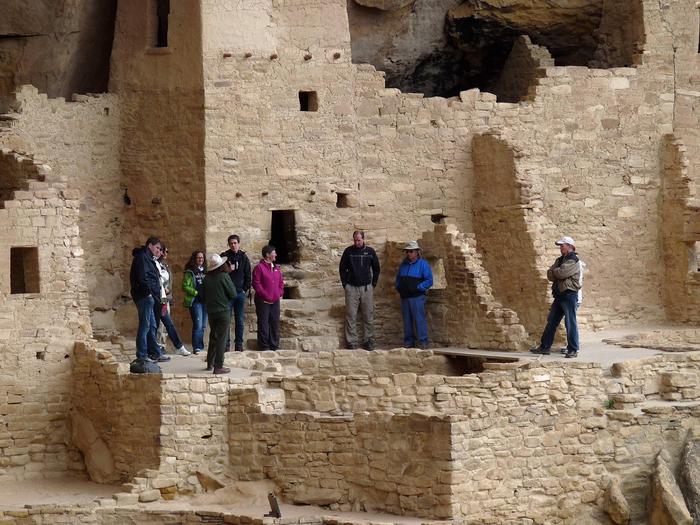 People with ranger in an ancient stone masonry village