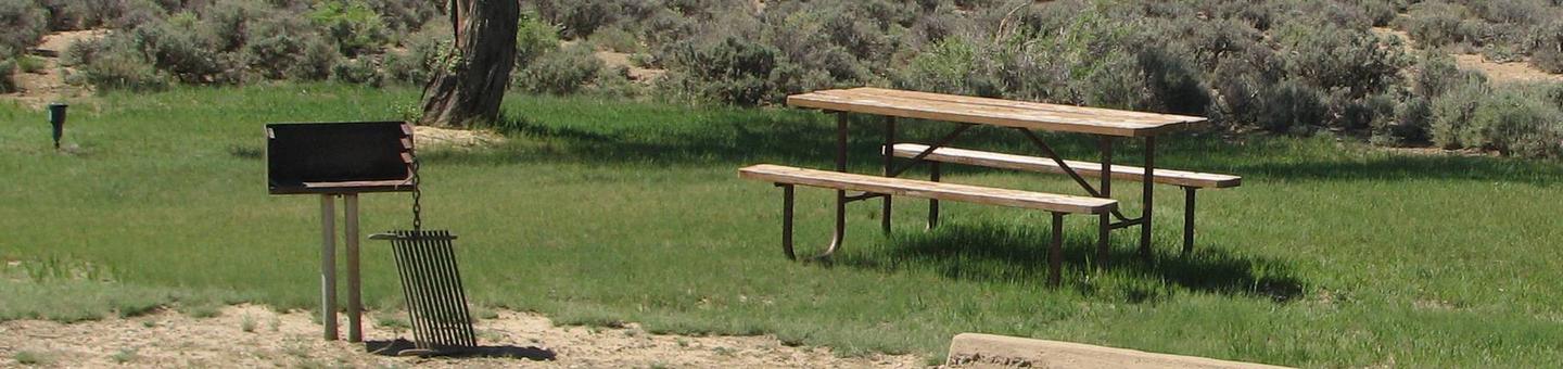 This site has a picnic table and a grill with a grill grate.Buckboard Crossing Campground: Loop B, Site 28