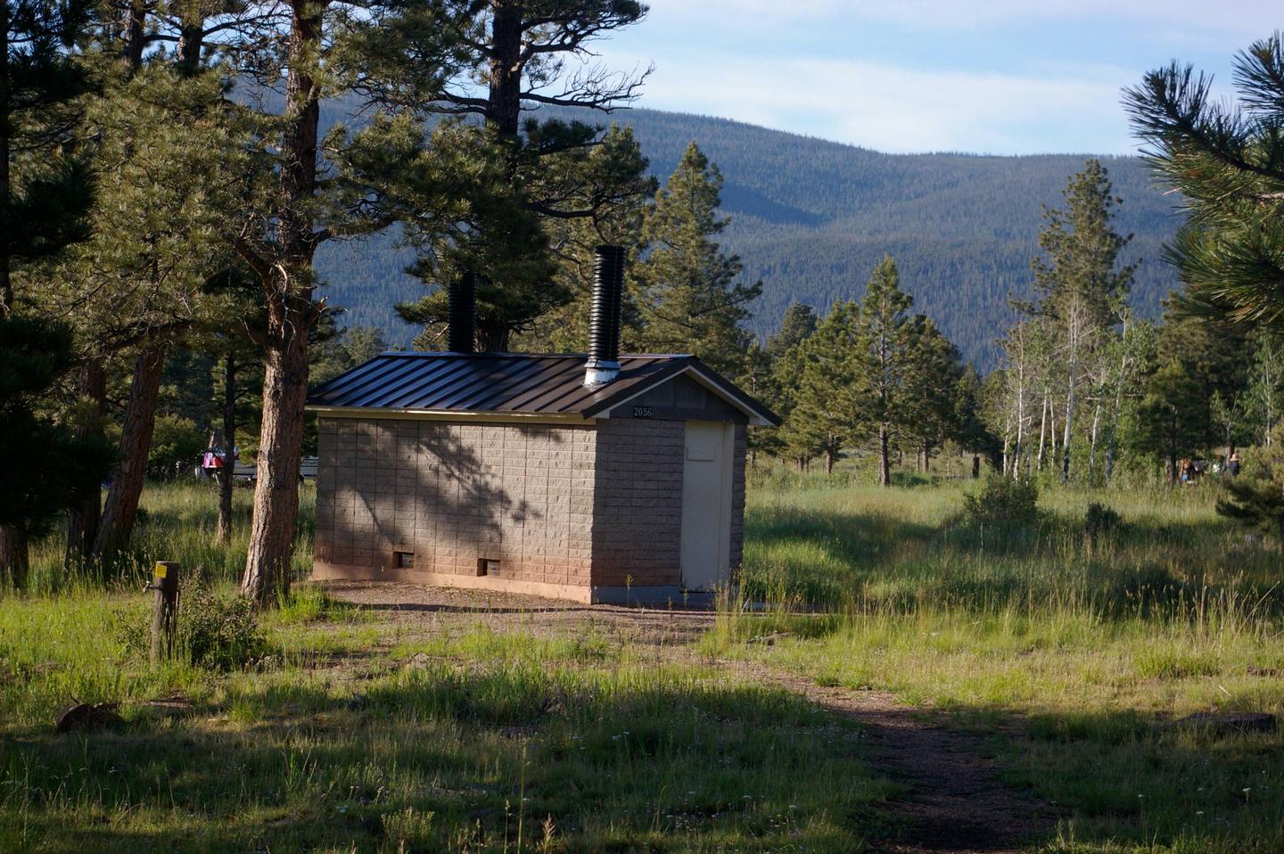 Brick building with a siding roof that houses the restrooms.Canyon Rim Campground: Restroom facilities