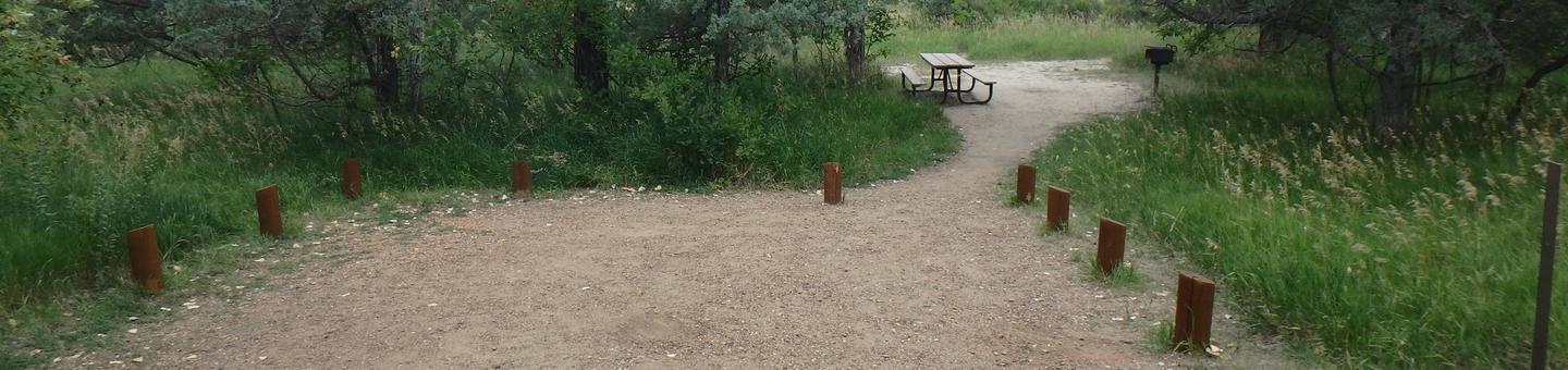 The picnic table and grill are located behind the site. There are wooden posts around the parking pad. Site 47, backin site. 