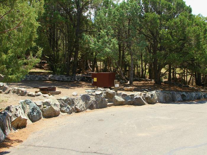View of Site #80 parallel parking area and tent site, with bear box, fire ring, and picnic table. Stairs go up from parking area to tent pad. Parking pad is not flat with a moderate grade. Slide outs not recommended due to width of road. Site #80, Pinon Flats Campground