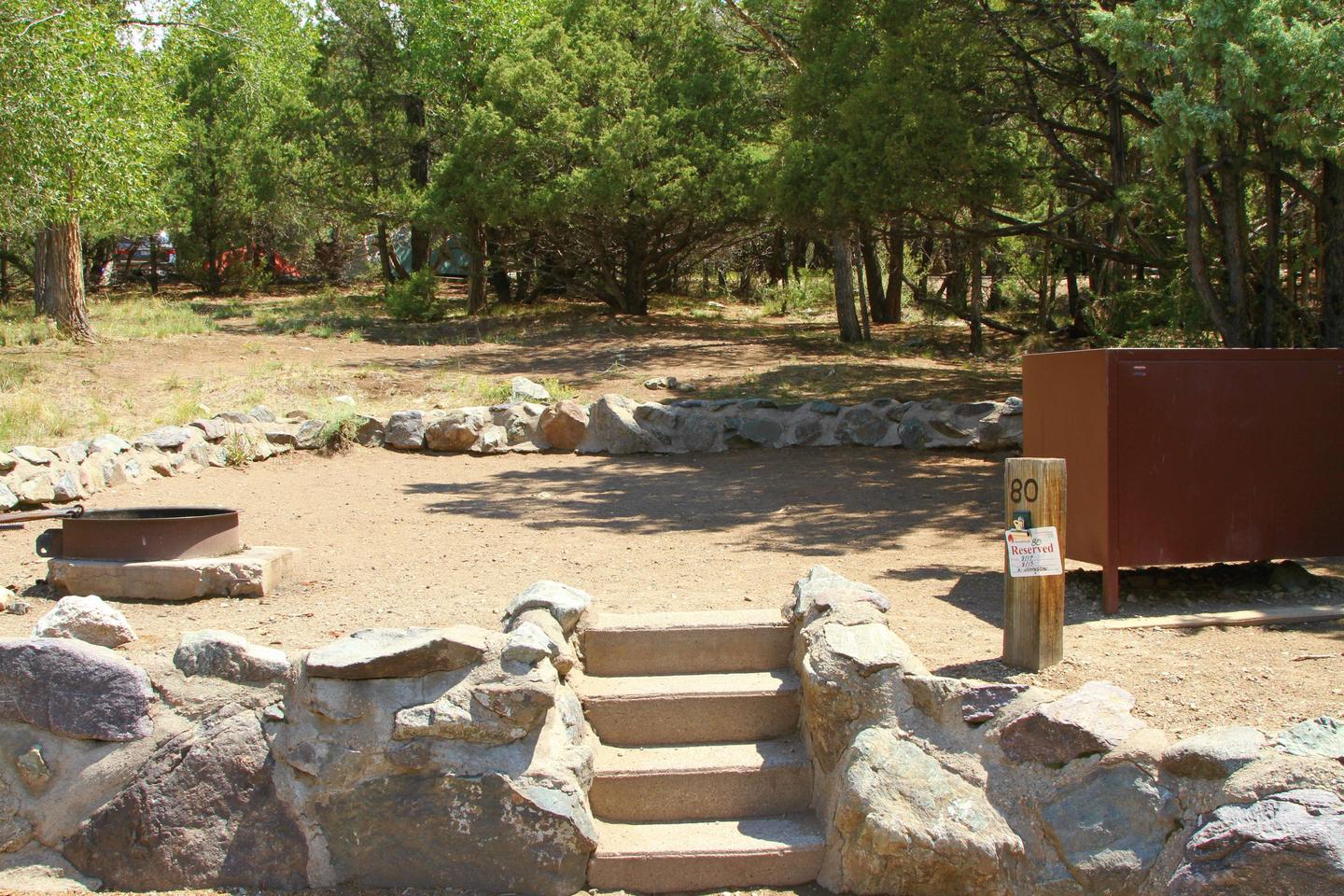 Closer view from parking area of Site #80 tent pad, with stairs leading up from road, fire ring, and bear box. Site #80, Pinon Flats Campground