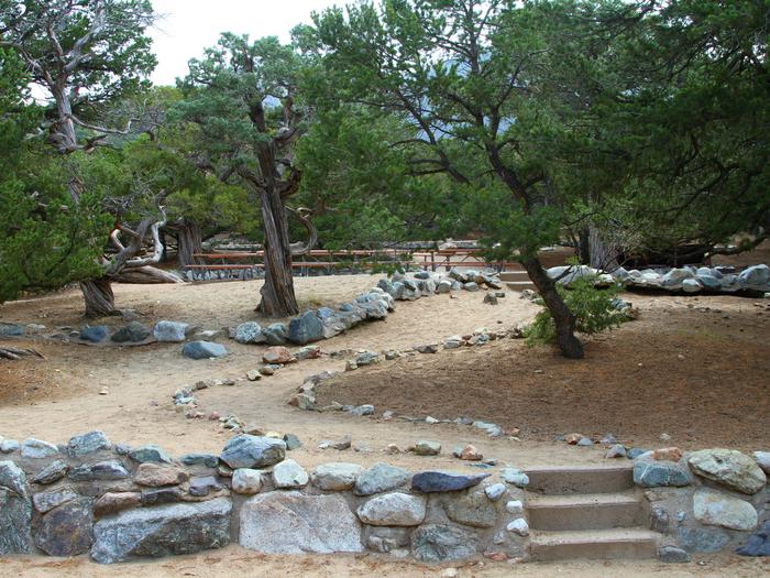 View of Group Site "A" entrance path from the parking area. Trail has three stairs and is bordered by a line of rocks that go up to another three stairs to the actual tent area.Group Site A, Pinon Flats Campground