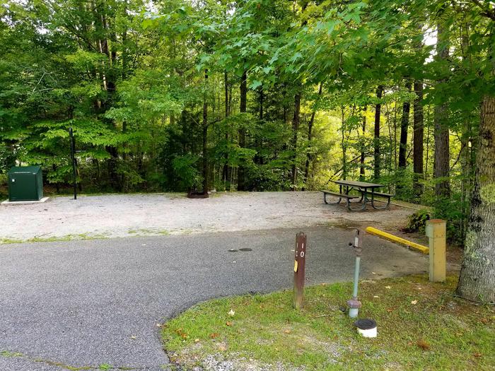 Paved parking area next to gravel tent pad and picnic table.Blue Heron Campground Site 10