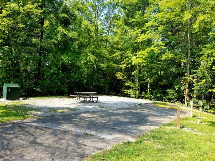 Paved parking area next to gravel tent pad and picnic table.Blue Heron Campground Site 34