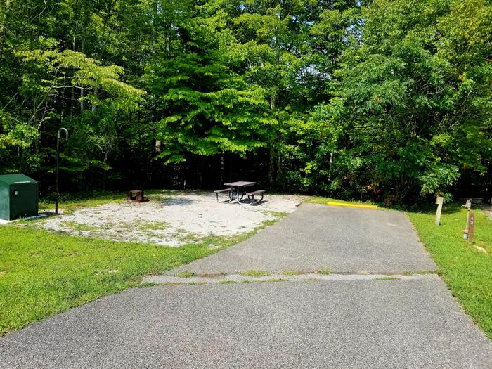 Paved parking lane next to gravel tent pad and picnic table.Blue Heron Campground Site 43
