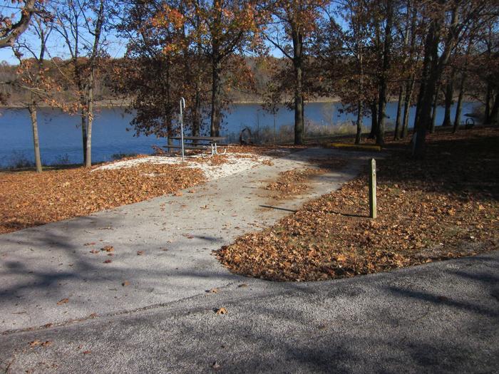 Electric site with paved/gravel pad, picnic table, fire ring, lantern post, and short walk to lake.Ruark West site 7