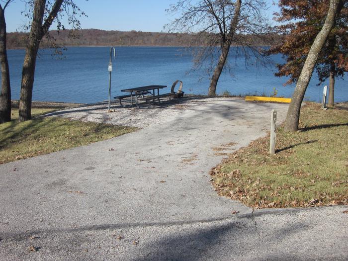 Electric site with paved/gravel pad, picnic table, fire ring, lantern post, and great lake frontage.Ruark West Site 17
