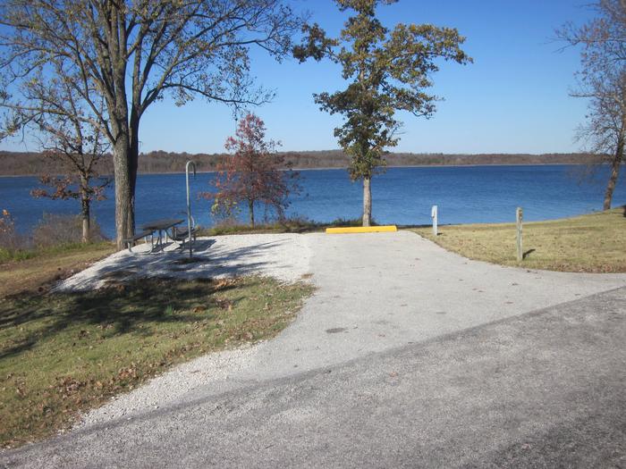 Electric site with paved/gravel pad, picnic table, fire ring, lantern post, and excellent lake frontage.Ruark West site 19