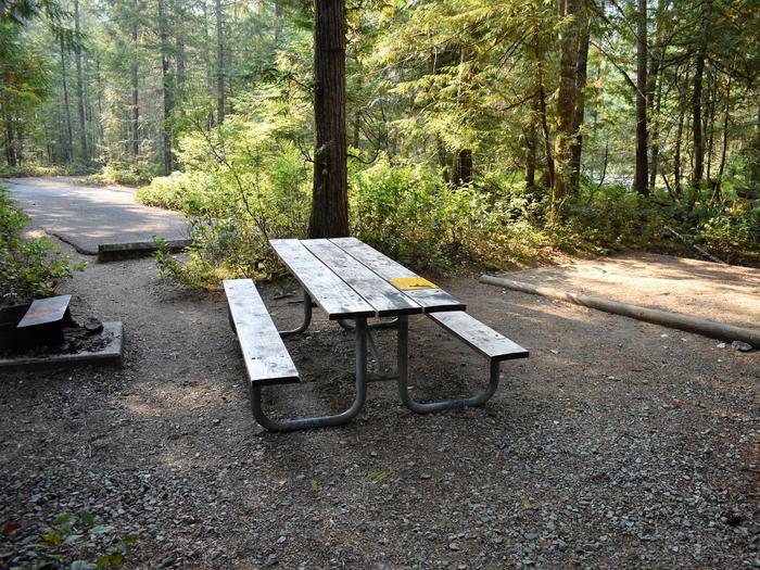 Picnic table and tent pad with driveway in distanceView of tent pad for site