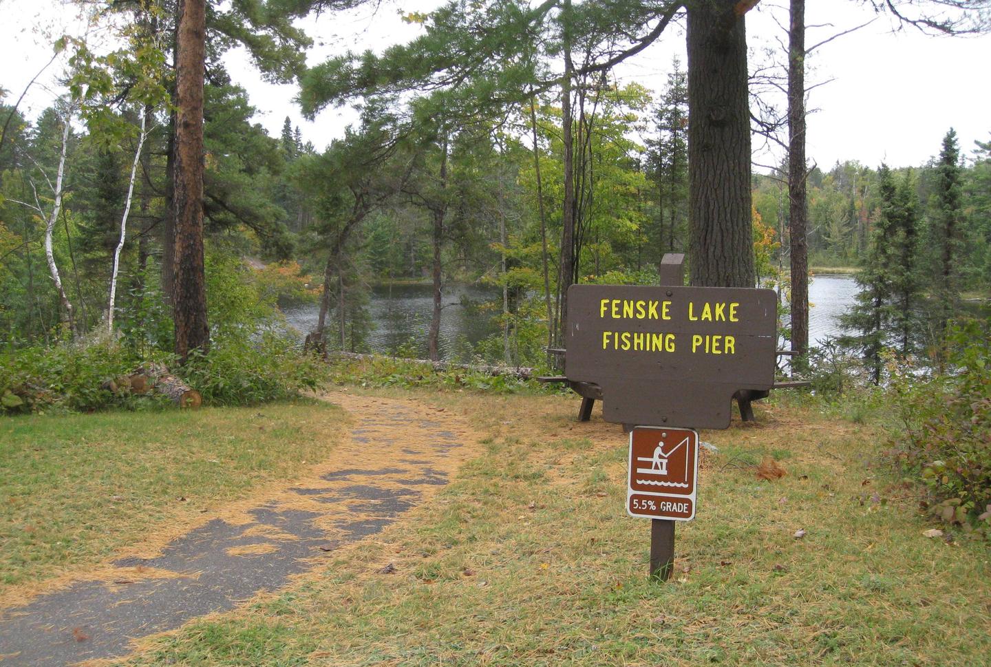 Picture of paved trail and sign.Fenske Lake fishing pier access trail.  Paved trail provides access to the fishing pier.