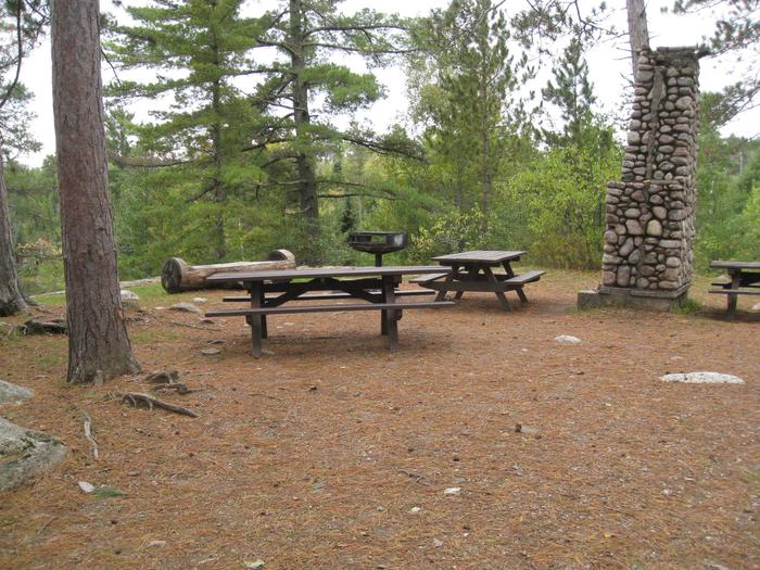 Picture of picnic tables.Group camping area with picnic tables and grill.