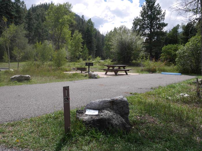 Site 1 with a picnic table, fire ring, camp grill, and parking.